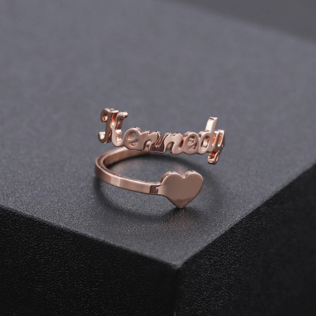 A personalized Heart Name Ring made of gold with engraved names and heart-shaped design