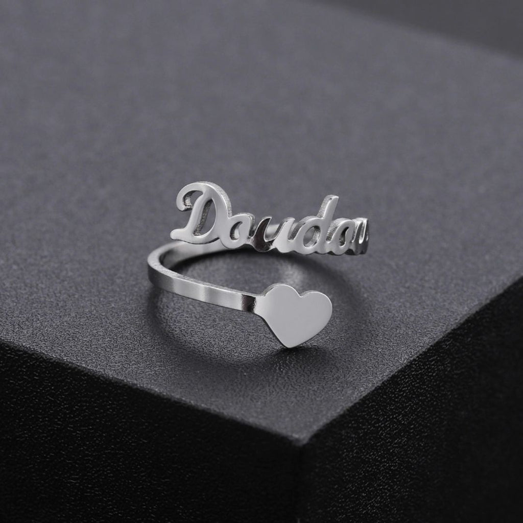 A personalized Heart Name Ring made of gold with engraved names and heart-shaped design