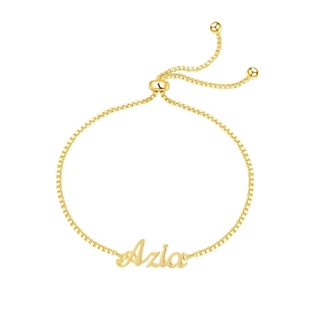 A delicate gold bracelet with small name charms hanging from it. The name charms are customizable with your own choice of letters and font styles, making it a perfect personalized accessory